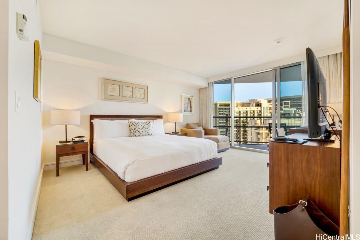 223 Saratoga Road, Unit 2006 Honolulu, HI 96815 - Photo 13 of 15 a bedroom with a large bed and a flat tv screen on dresser