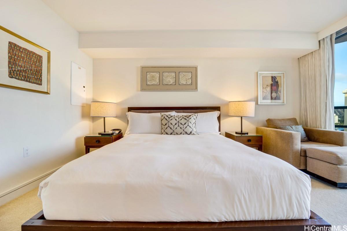 223 Saratoga Road, Unit 2006 Honolulu, HI 96815 - Photo 2 of 15 a bedroom with a bed and wooden floor