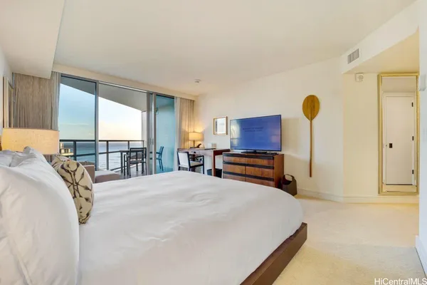 a bedroom with a bed and dresser with mirror