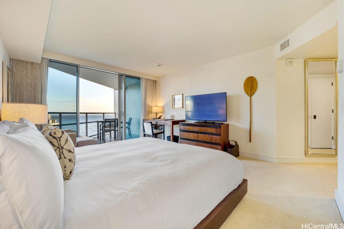 223 Saratoga Road, Unit 2006 Honolulu, HI 96815 - Photo 3 of 15 a bedroom with a bed and dresser with mirror