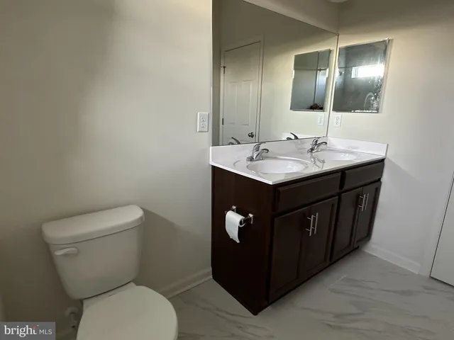 a bathroom with a toilet sink and mirror