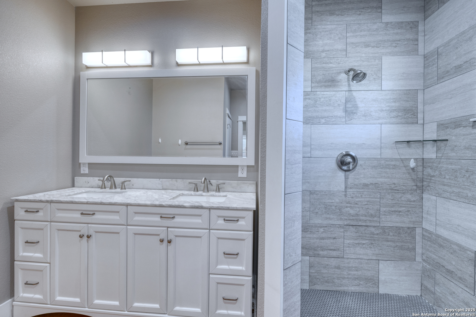 413 Guajillo Uvalde, TX 78801 - Photo 11 of 23 a bathroom with a granite countertop sink a mirror and a shower