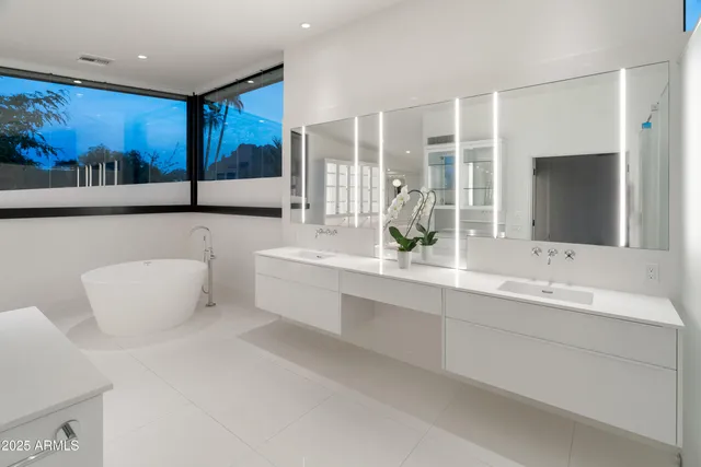 a white kitchen with a sink a refrigerator and cabinets