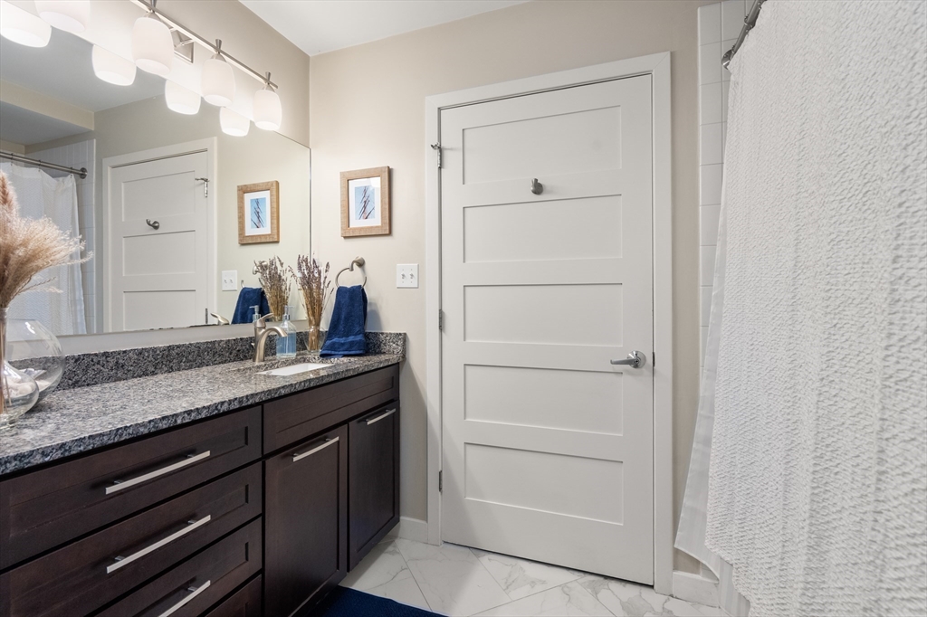 156-168 Terrace Street, Unit 402 Boston, MA 02120 - Photo 13 of 31 a bathroom with a granite countertop sink and a mirror