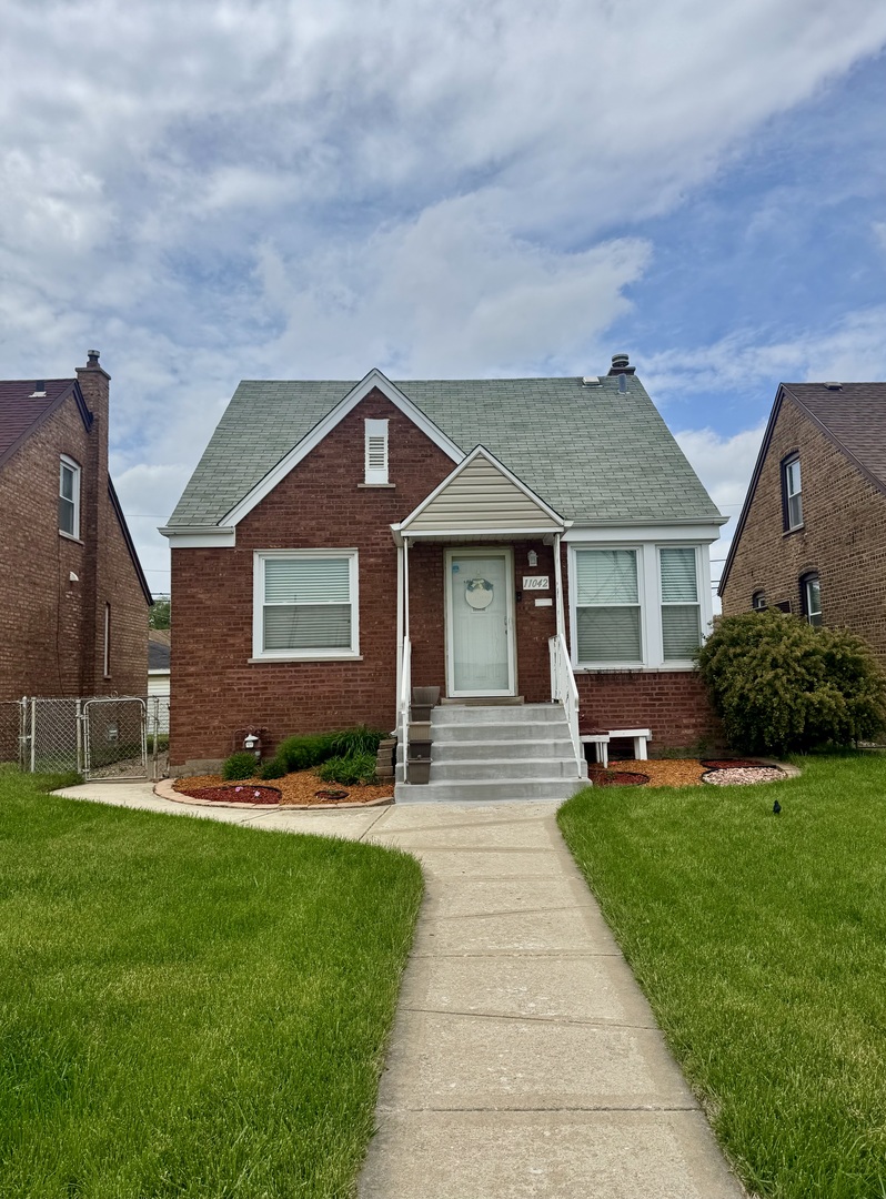 11042 South State Line Road Chicago, IL 60617 - Photo 1 of 12 a front view of a house with a garden and yard