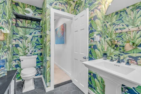 a white toilet sitting next to a bathroom sink