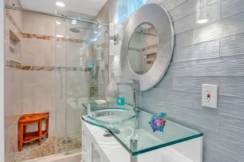 a bathroom with a granite countertop sink a toilet and shower