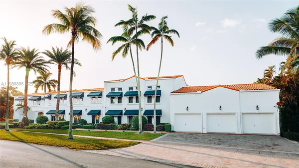 a view of a white building with a palm trees