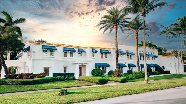 a front view of multi story residential apartment building with yard and green space