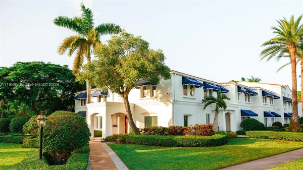 a front view of a residential houses with yard and green space