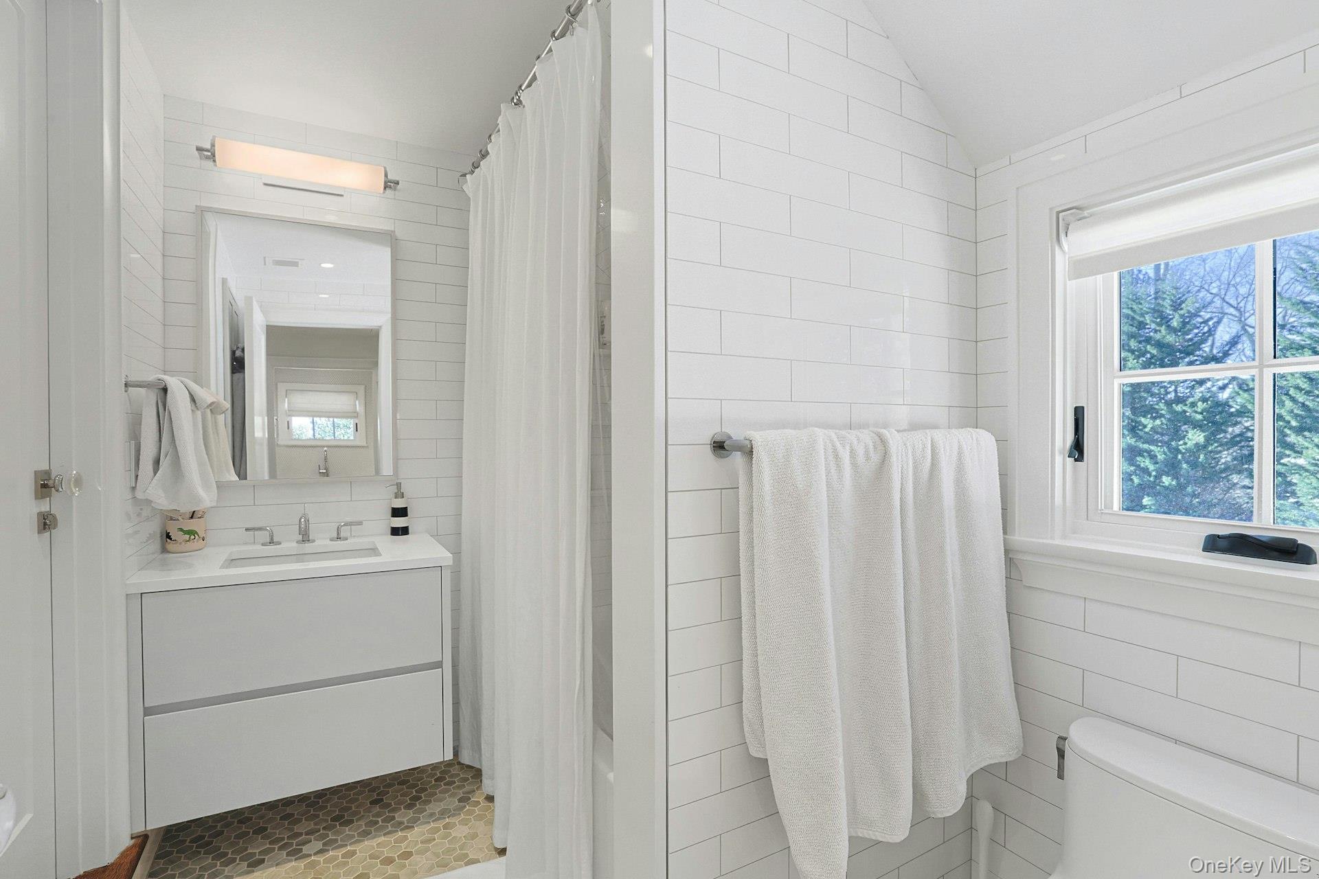 19 Overlook Road Scarsdale, NY 10583 - Photo 36 of 50 a bathroom with a double vanity sink a mirror and a bathtub
