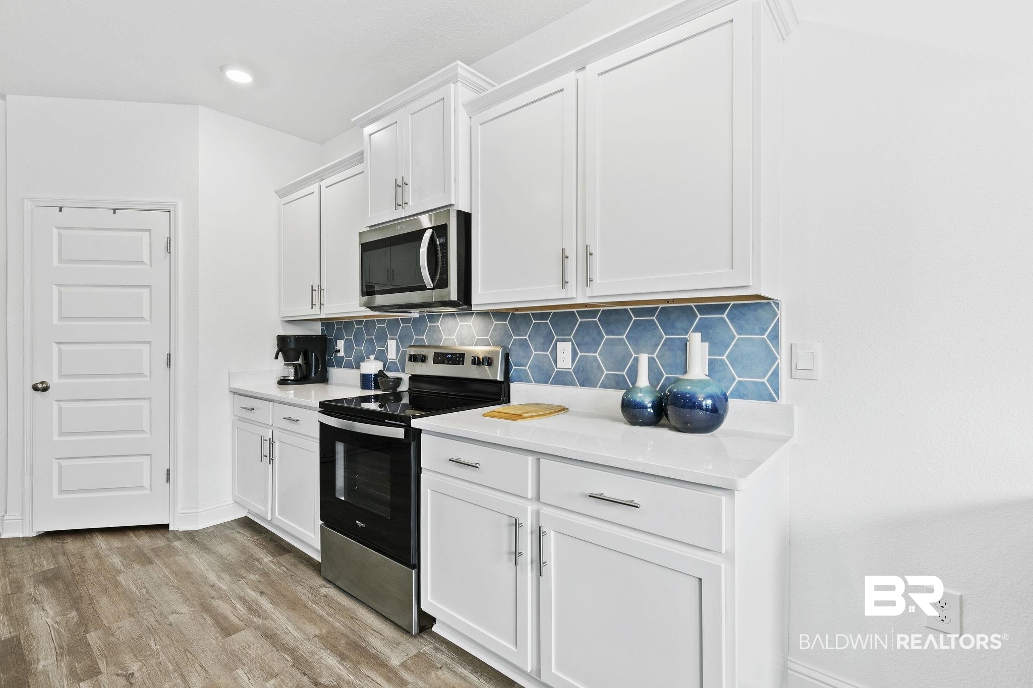 1141 Pencarro Boulevard Foley, AL 36535 - Photo 19 of 70 Kitchen with white cabinetry, decorative backsplash, stainless steel appliances, and light wood-type flooring