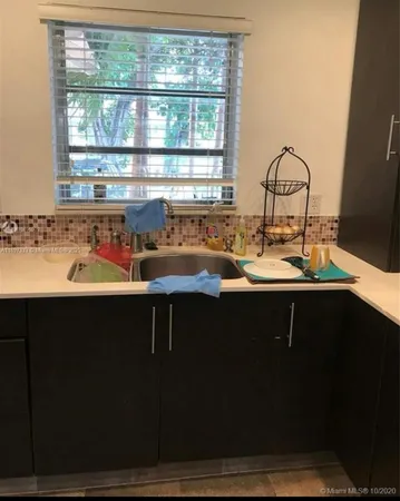 a kitchen with a sink a window and cabinets