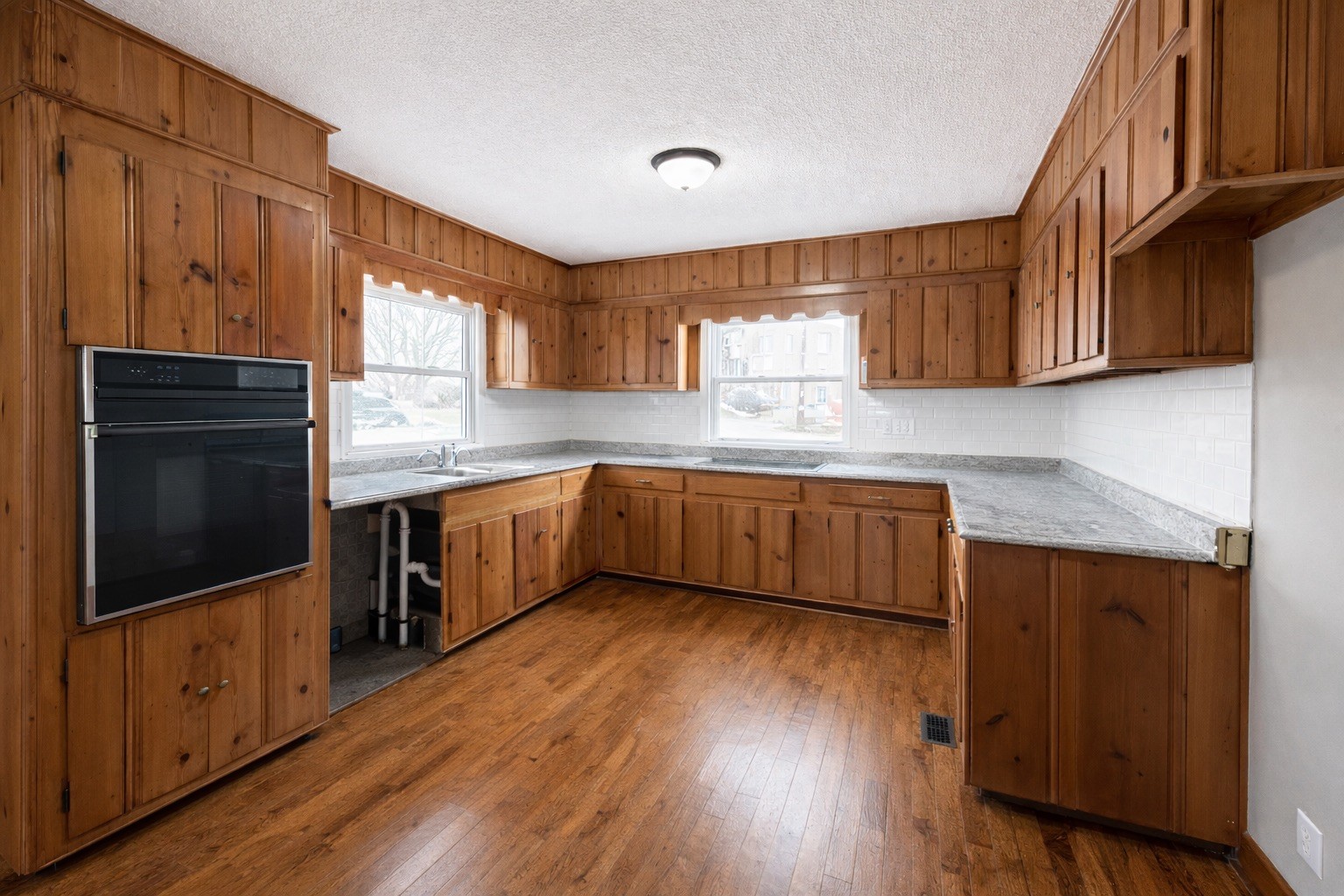 109 Apple Tree Street Arlington, KY 42021 - Photo 2 of 18 a kitchen with stainless steel appliances kitchen island granite countertop wooden floors wooden cabinets a sink and a counter space