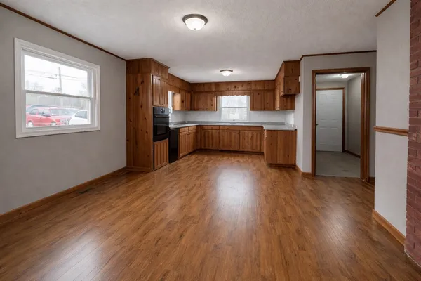 a kitchen with stainless steel appliances wooden floors and large window