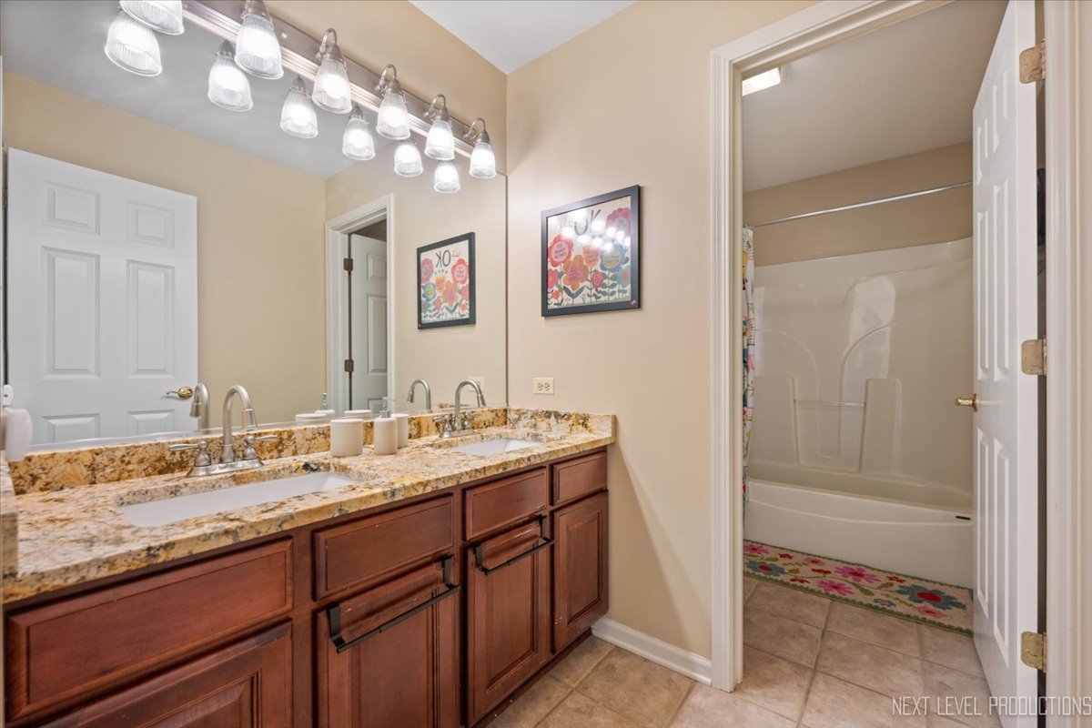 2236 Red Maple Lane Aurora, IL 60502 - Photo 29 of 50 a bathroom with a granite countertop sink a mirror and a
