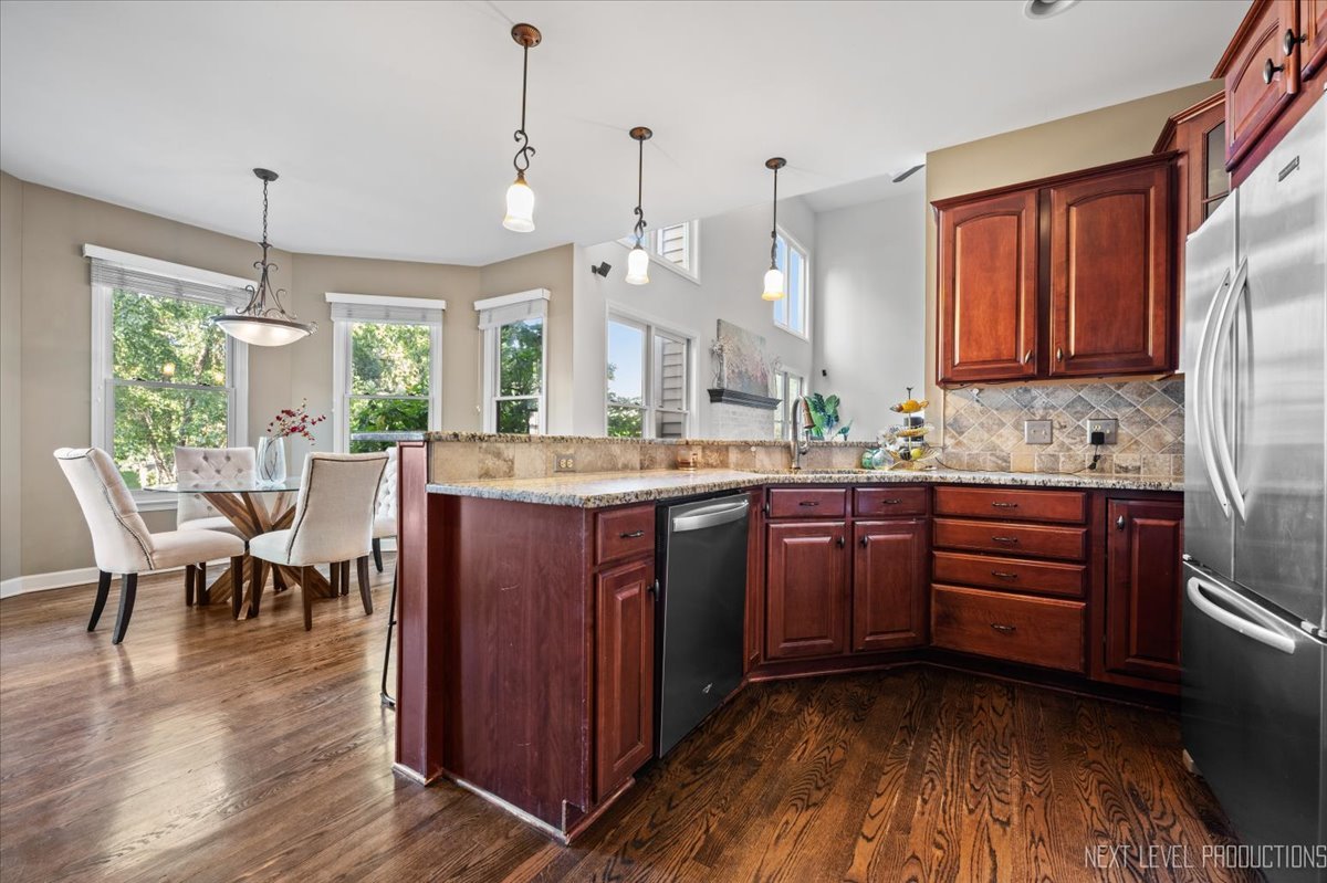 2236 Red Maple Lane Aurora, IL 60502 - Photo 9 of 50 a kitchen with kitchen island granite countertop wooden floors and sink