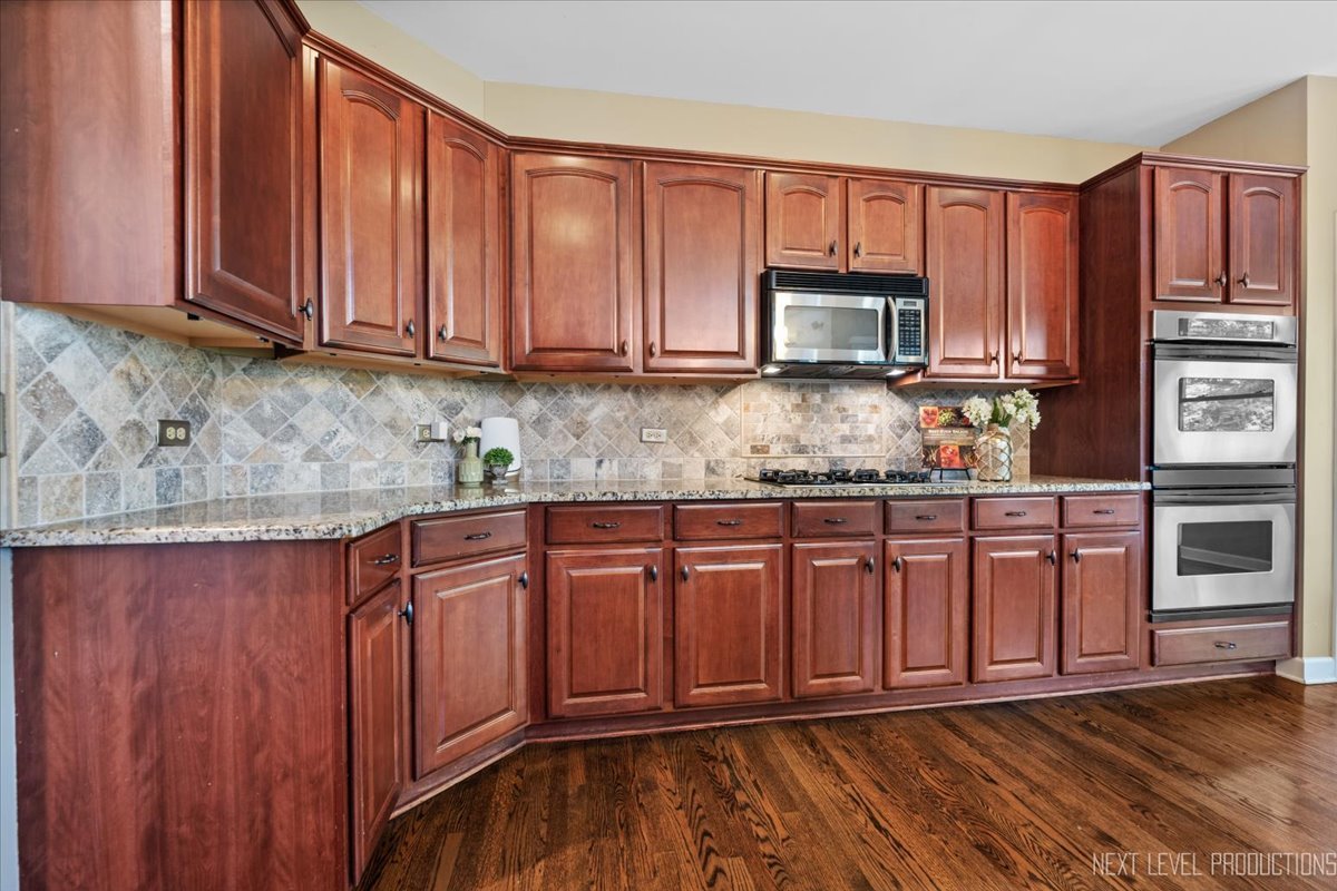 2236 Red Maple Lane Aurora, IL 60502 - Photo 10 of 50 a kitchen with stainless steel appliances granite countertop wooden cabinets a stove top oven with granite countertops and cabinets