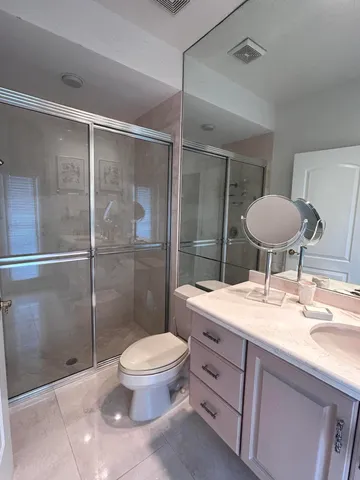 a bathroom with a double vanity sink toilet and shower