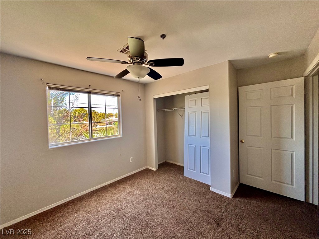 2011 Cutlass Drive Henderson, NV 89014 - Photo 34 of 41 Unfurnished bedroom featuring dark carpet, a closet, and ceiling fan