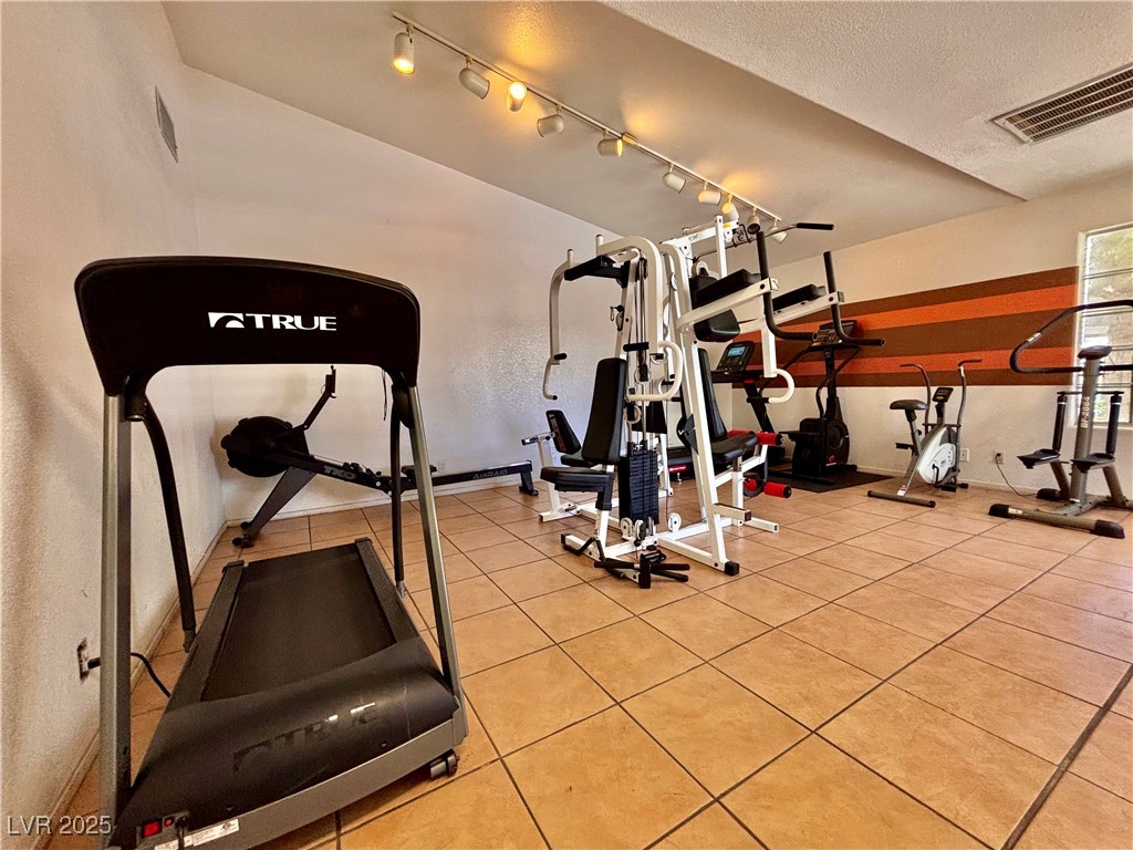 2011 Cutlass Drive Henderson, NV 89014 - Photo 40 of 41 Gym featuring a textured ceiling, light tile patterned flooring, and track lighting