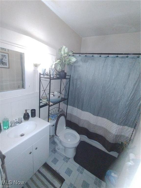 3114 Neosho Road Youngstown, OH 44511 - Photo 20 of 25 1st floor unit bathroom with tile patterned floors, a shower with curtain, and vanity