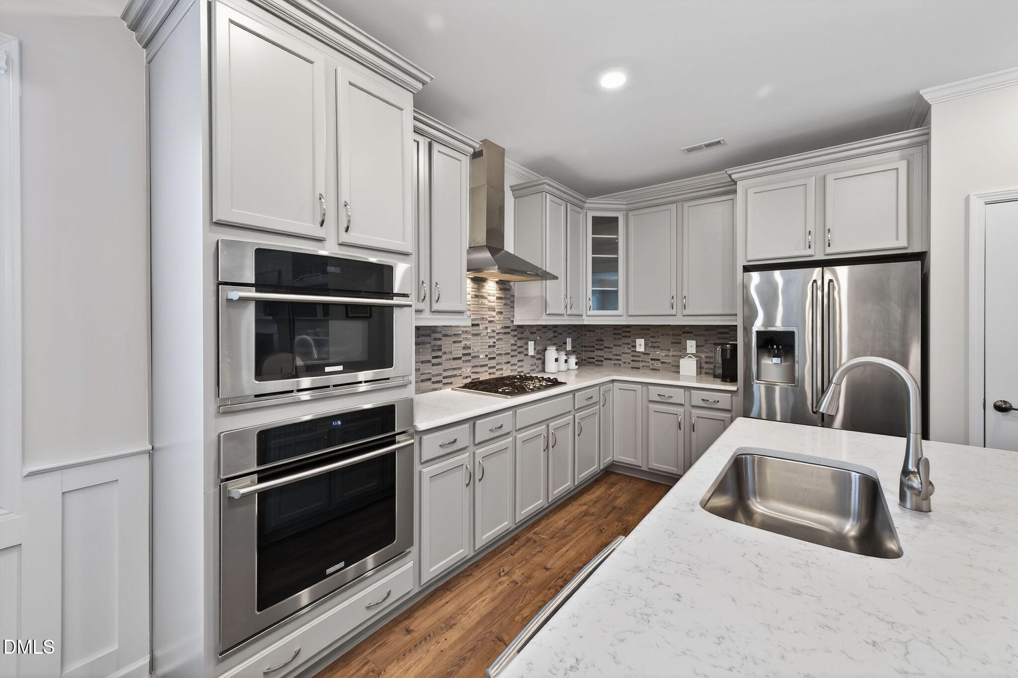 528 Spring Flower Court Cary, NC 27511 - Photo 18 of 51 a kitchen with white cabinets and stainless steel appliances