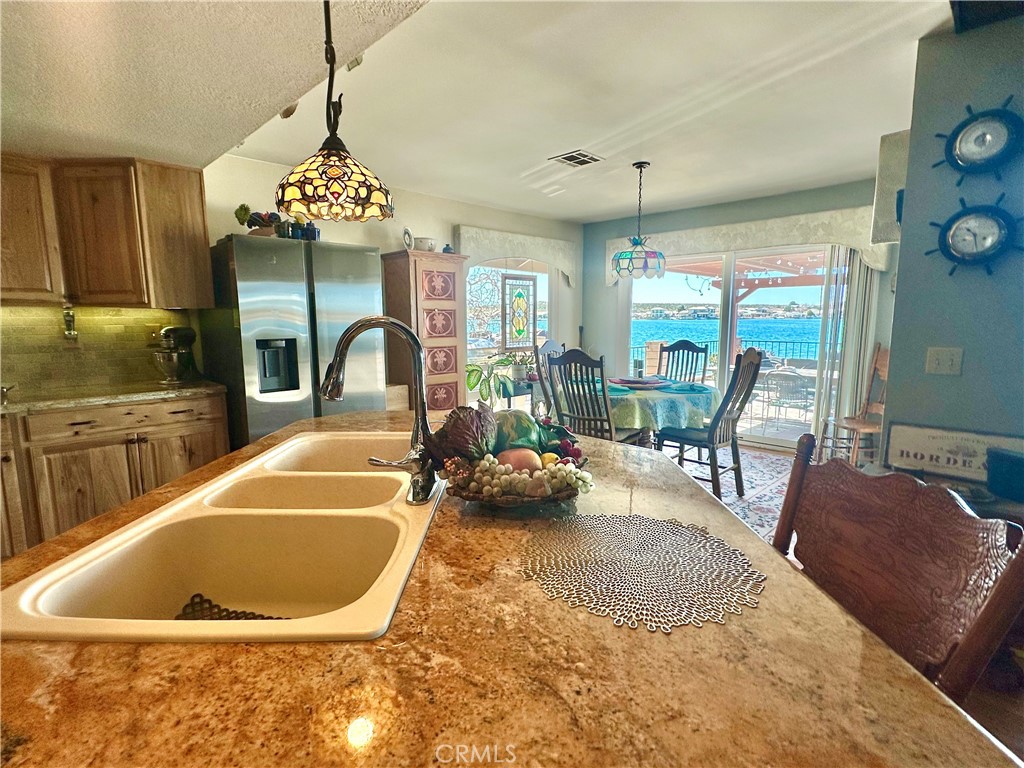 26576 Bluewater Road Helendale, CA 92342 - Photo 22 of 51 a view of a dining room and kitchen with furniture large window and chandelier