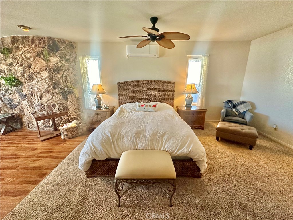 26576 Bluewater Road Helendale, CA 92342 - Photo 25 of 51 a bedroom with a bed and a chandelier