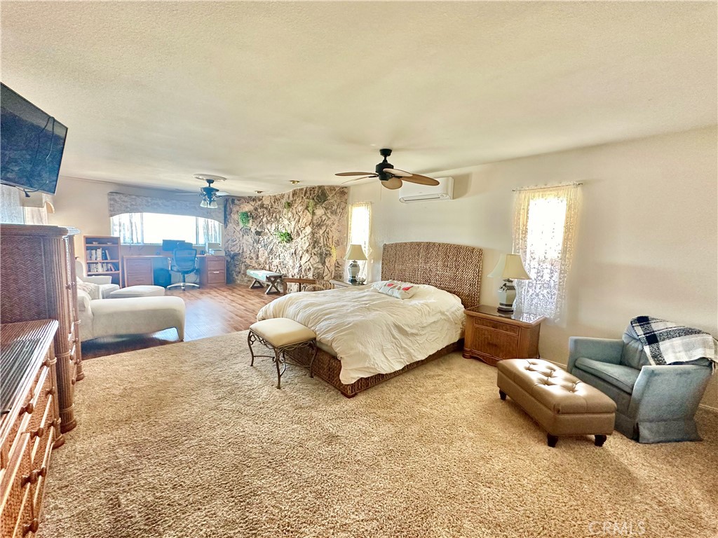 26576 Bluewater Road Helendale, CA 92342 - Photo 26 of 51 a spacious bedroom with a bed and a couch