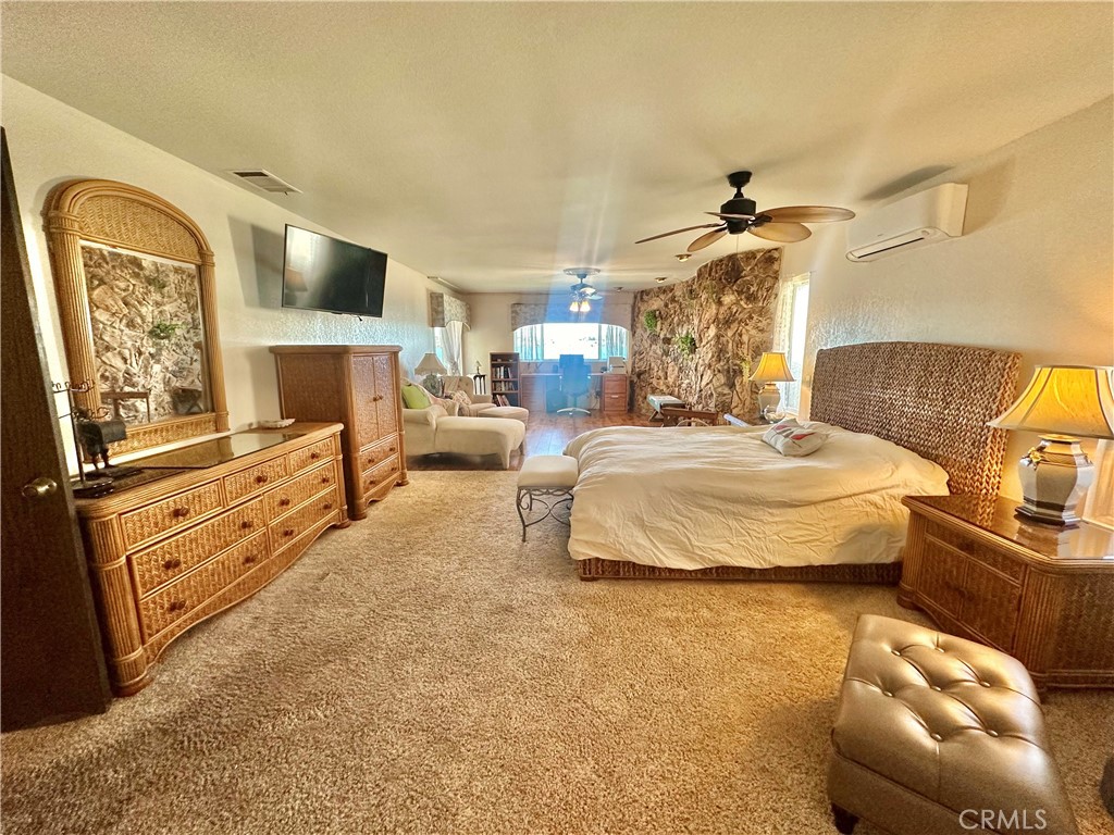 26576 Bluewater Road Helendale, CA 92342 - Photo 27 of 51 a spacious bedroom with a bed a couch and dresser