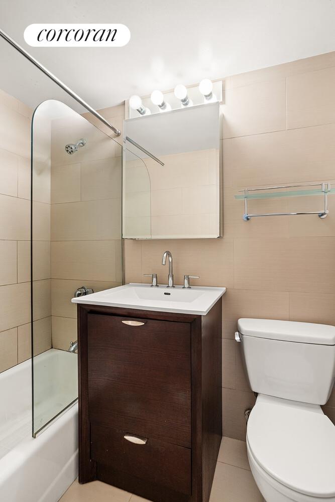 345 East 69th Street, Unit 16E Manhattan, NY 10021 - Photo 6 of 9 a bathroom with a toilet sink and mirror