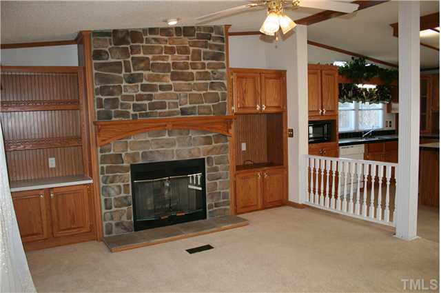 4053 Fairport Road Kittrell, NC 27544 - Photo 6 of 15 Beautiful family room with cathedral ceiling, stone fireplace and built in bookshelves. With the pillared wall separating the kitchen from the family room, it is a great place to gather.
