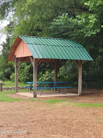 a backyard of a house with table and chairs under an umbrella