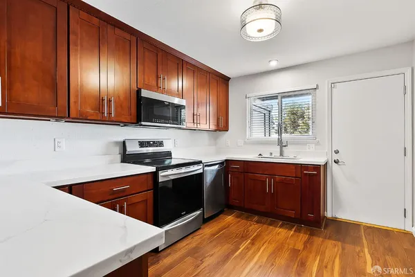 a kitchen with stainless steel appliances granite countertop wooden cabinets a stove a sink and dishwasher