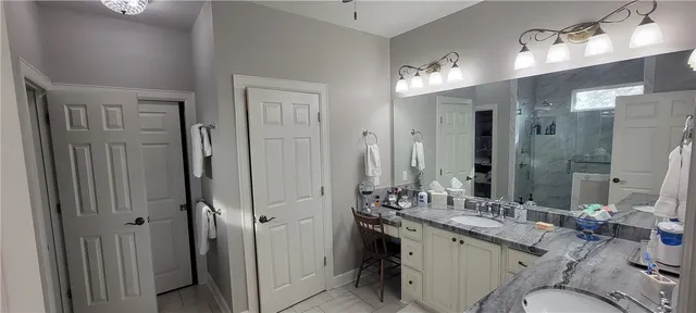 a bathroom with a double vanity sink mirror and shower