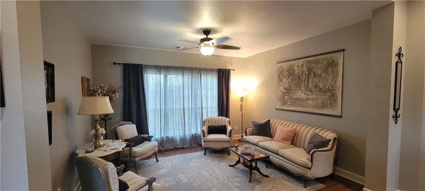 a living room with furniture and a ceiling fan