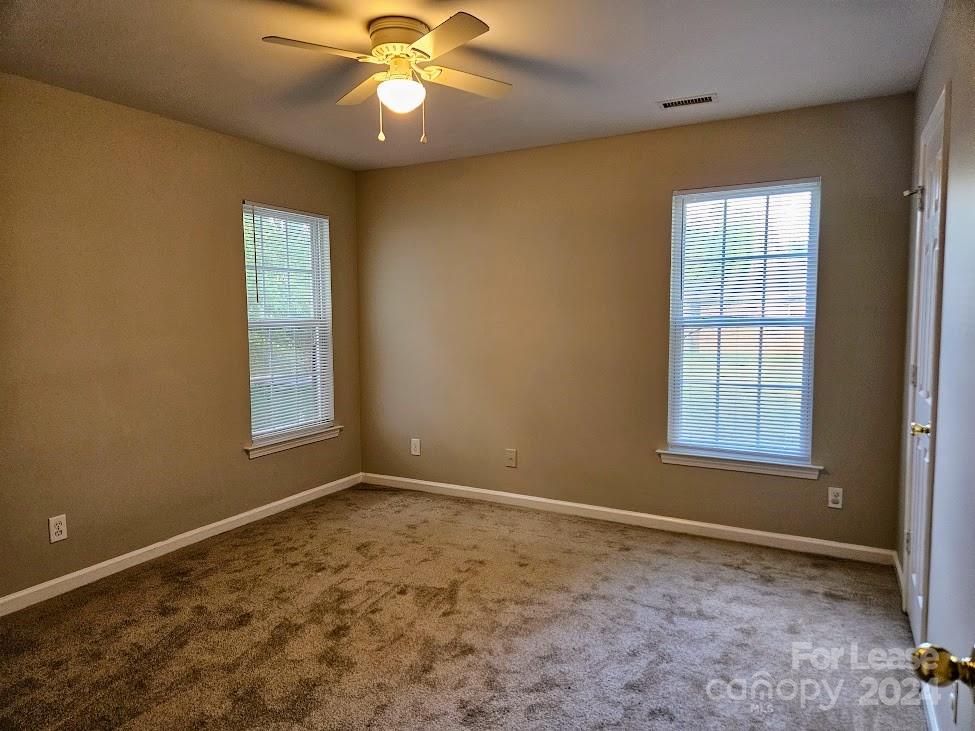 1207 Auten Road, Unit B Charlotte, NC 28216 - Photo 14 of 17 a view of an empty room with window and chandelier fan