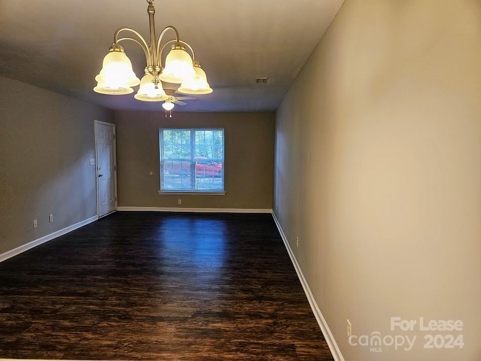1207 Auten Road, Unit B Charlotte, NC 28216 - Photo 7 of 17 an empty room with wooden floor chandelier and windows