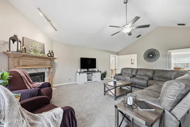 a living room with furniture a flat screen tv and a fireplace