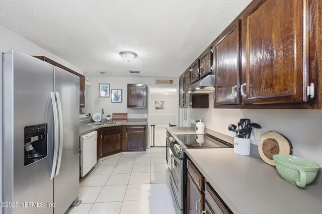 a kitchen with stainless steel appliances granite countertop a refrigerator and a stove top oven