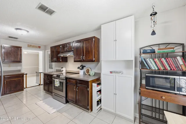 a kitchen with stainless steel appliances granite countertop a stove top oven a sink dishwasher and a refrigerator
