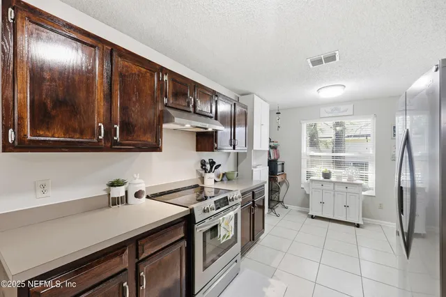 a kitchen with stainless steel appliances a sink stove and cabinets