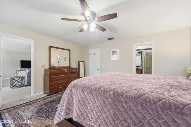 a bedroom with a bed and dresser with mirror