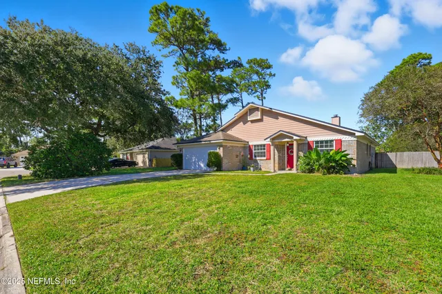 an aerial view of residential house with outdoor space and trees all around
