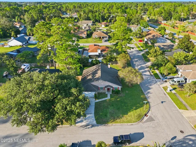 an aerial view of a house with a yard and lake view