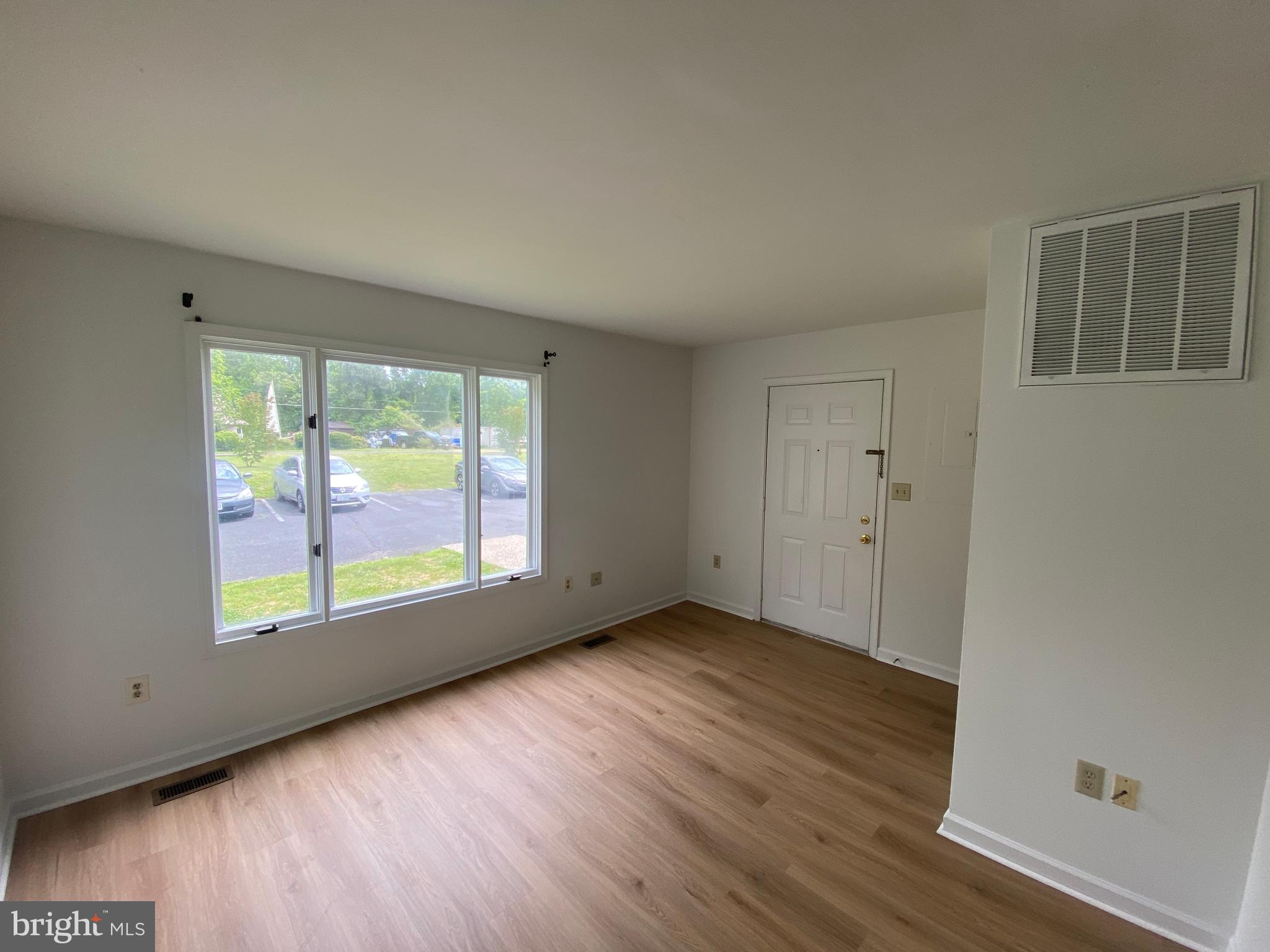 9298 Hayden Drive, Unit 14 King George, VA 22485 - Photo 5 of 17 an empty room with wooden floor and windows