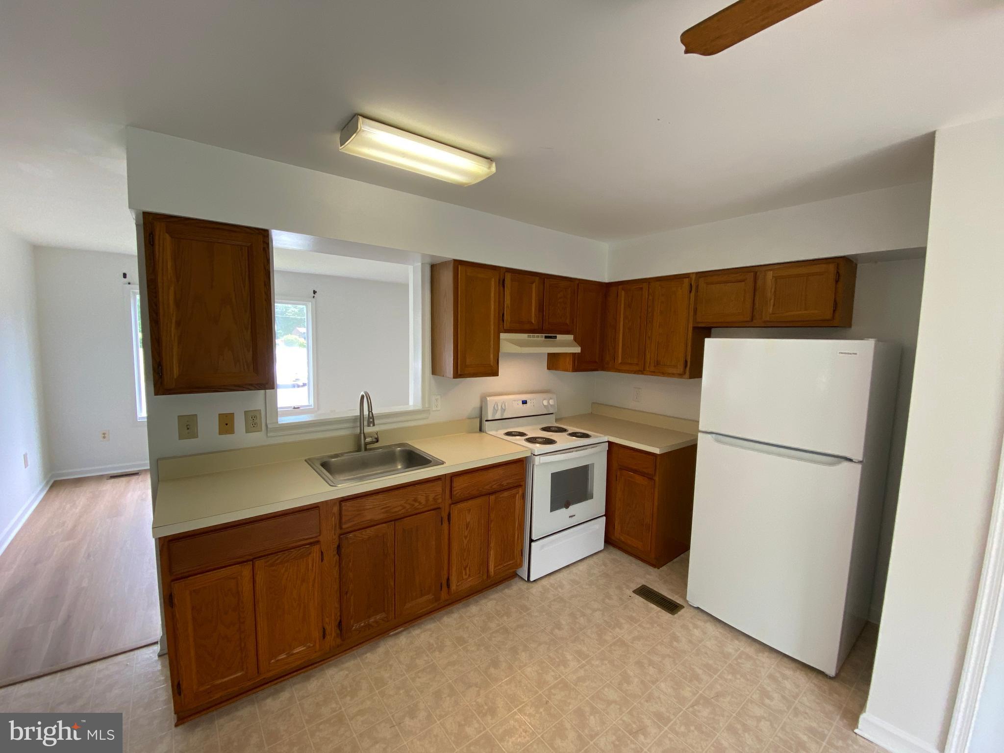 9298 Hayden Drive, Unit 14 King George, VA 22485 - Photo 6 of 17 a kitchen with a sink and a refrigerator