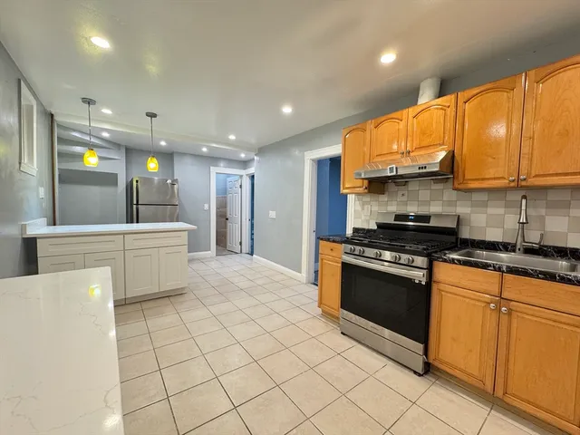 a kitchen with stainless steel appliances granite countertop a stove a sink and a refrigerator