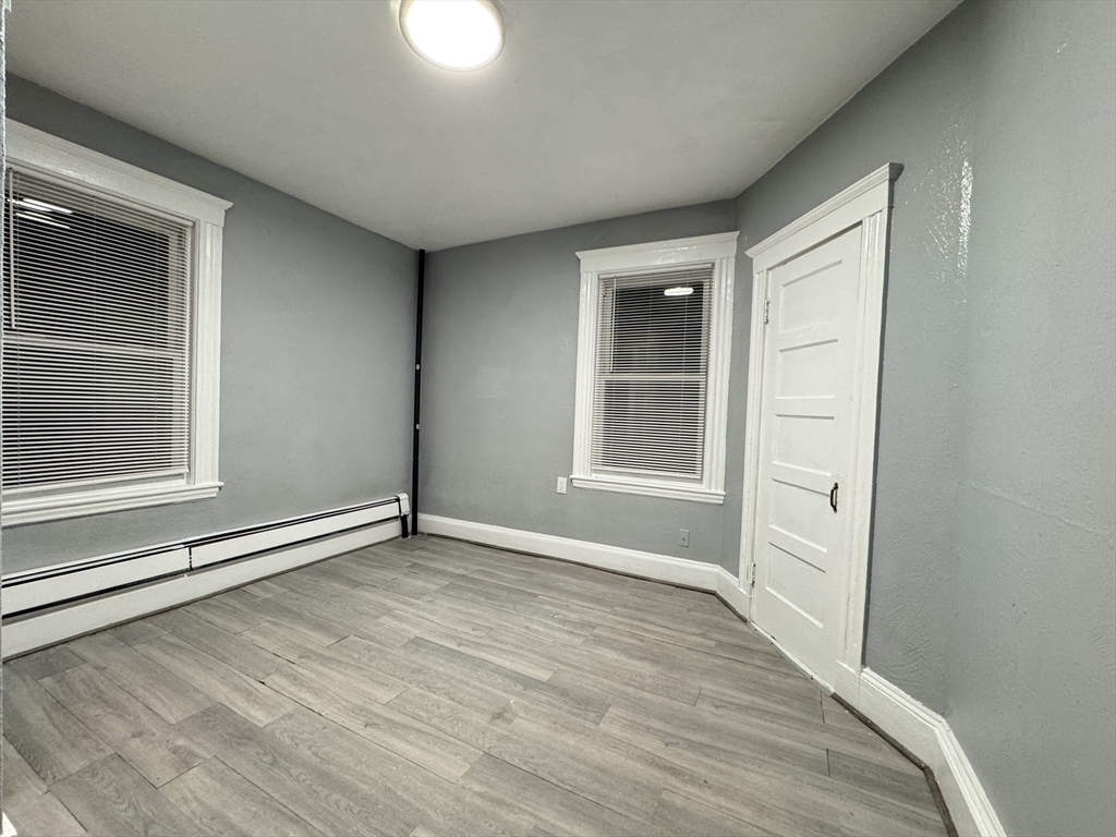 10 Faxon Road, Unit 1 Quincy, MA 02171 - Photo 6 of 11 a view of an empty room with wooden floor and a window